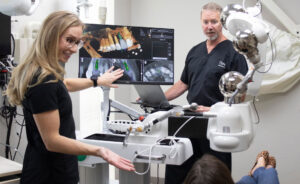 Dr. Bouma and Dr. Wright talking with patient about dental images on computer screen