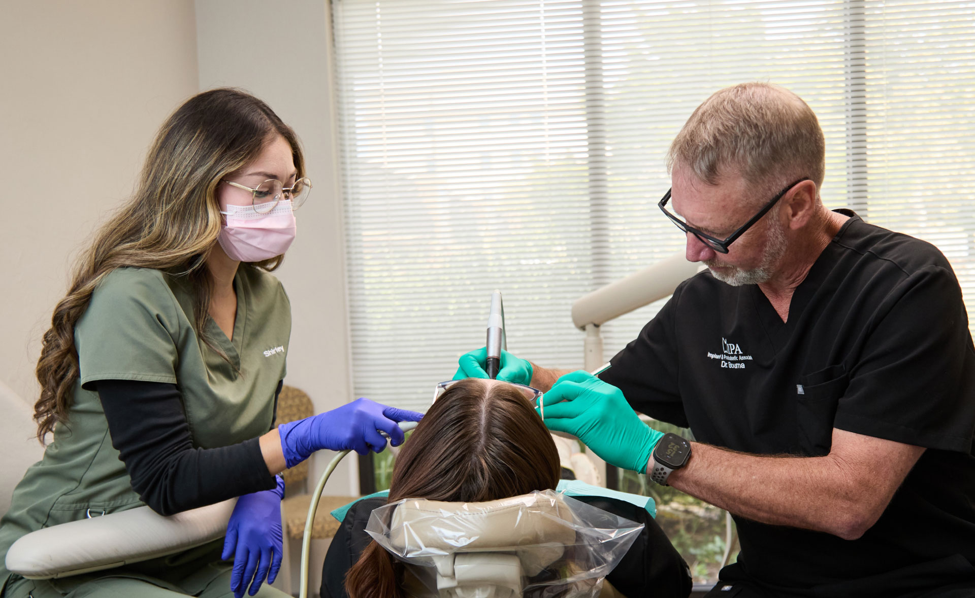 Dr. Bouma and assistant performing dental exam on patient